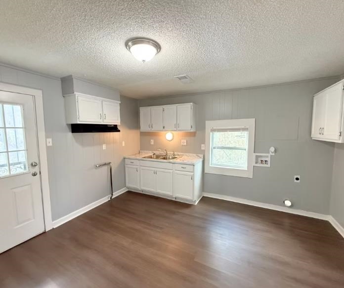 433 Dixie Road Memphis, TN 38109 - Photo 3 of 11 a kitchen with granite countertop white cabinets and wooden floor