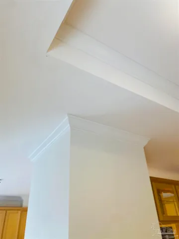 an empty room with windows and chandelier fan