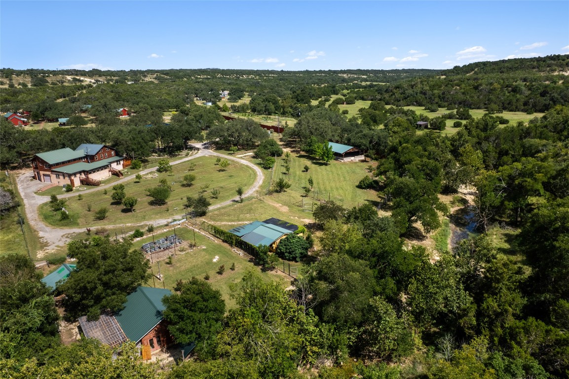 an aerial view of residential houses with outdoor space and trees