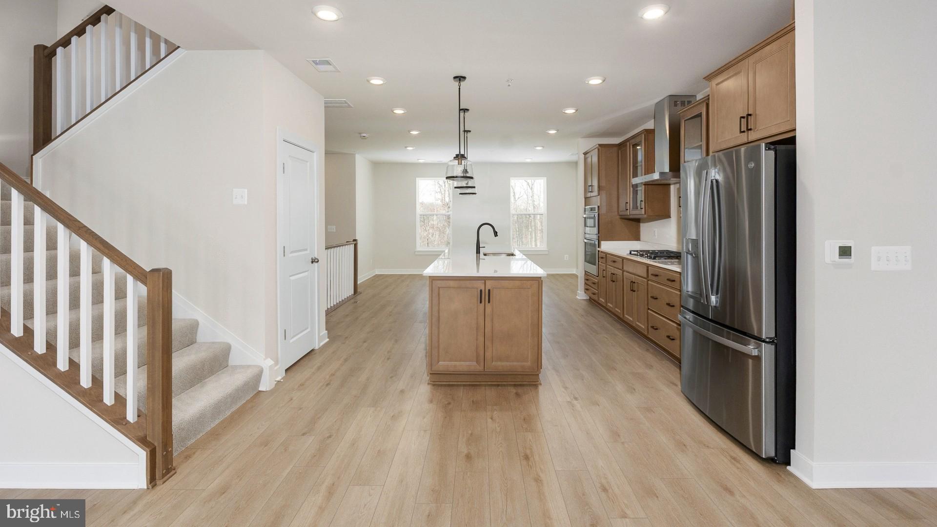 20821 Cloongee Terrace Sterling, VA 20166 - Photo 10 of 34 a kitchen with stainless steel appliances a refrigerator and a wooden floor