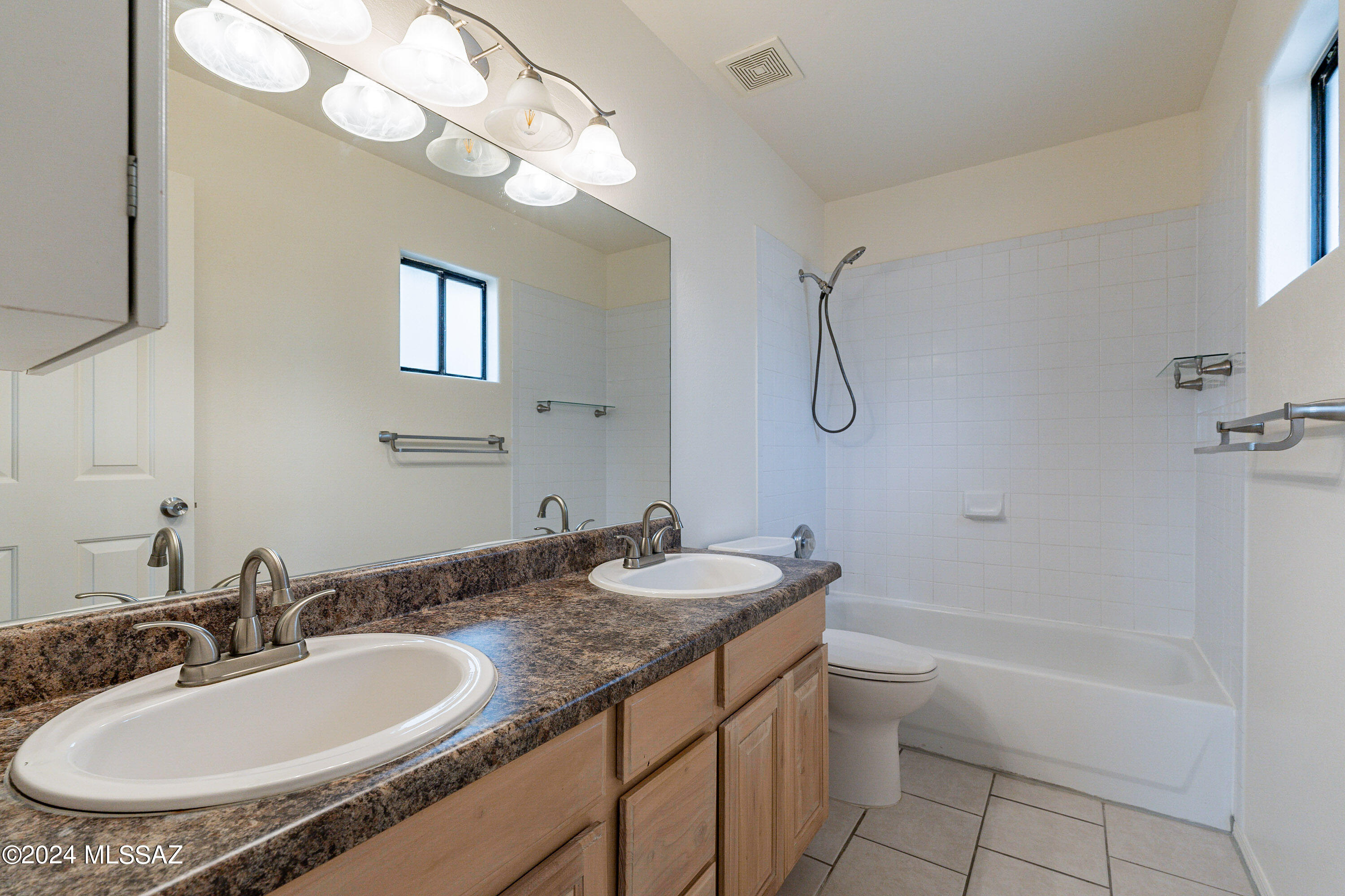 1380 Camino Faja Rio Rico, AZ 85648 - Photo 17 of 28 a bathroom with a granite countertop sink a toilet and a mirror