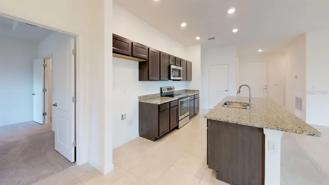 a view of a kitchen with a sink a microwave and cabinets