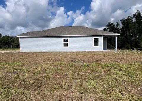 a front view of a house with yard and trees