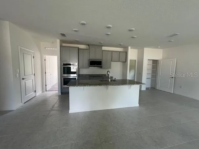 a view of a kitchen with refrigerator and microwave