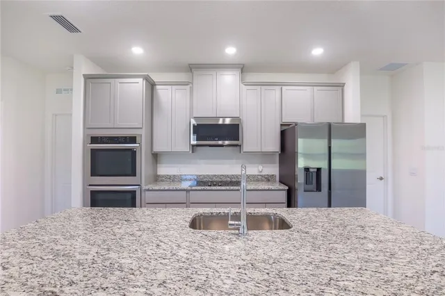 a kitchen with kitchen island a counter top stainless steel appliances and sink