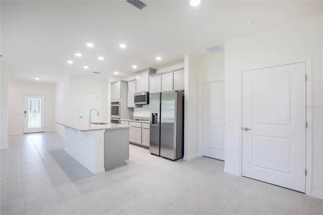 a view of kitchen with refrigerator sink and cabinets