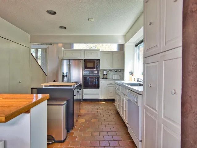 a kitchen with granite countertop a sink and a refrigerator