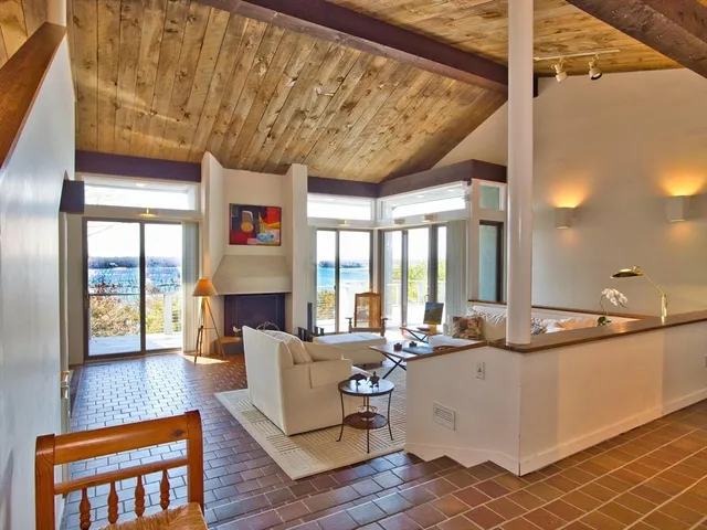 a living room with fireplace furniture and a large window