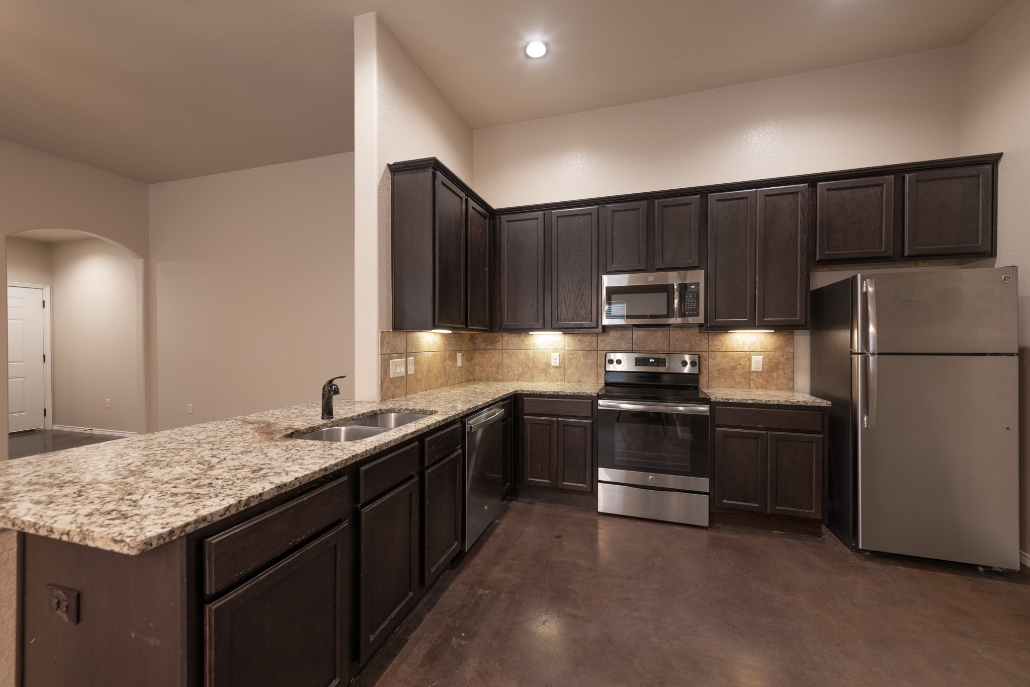 424 Jack Rabbit Lane, Unit B Buda, TX 78610 - Photo 8 of 20 a kitchen with stainless steel appliances granite countertop a refrigerator a stove a sink and a microwave