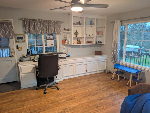 a view of a workspace with furniture and a window
