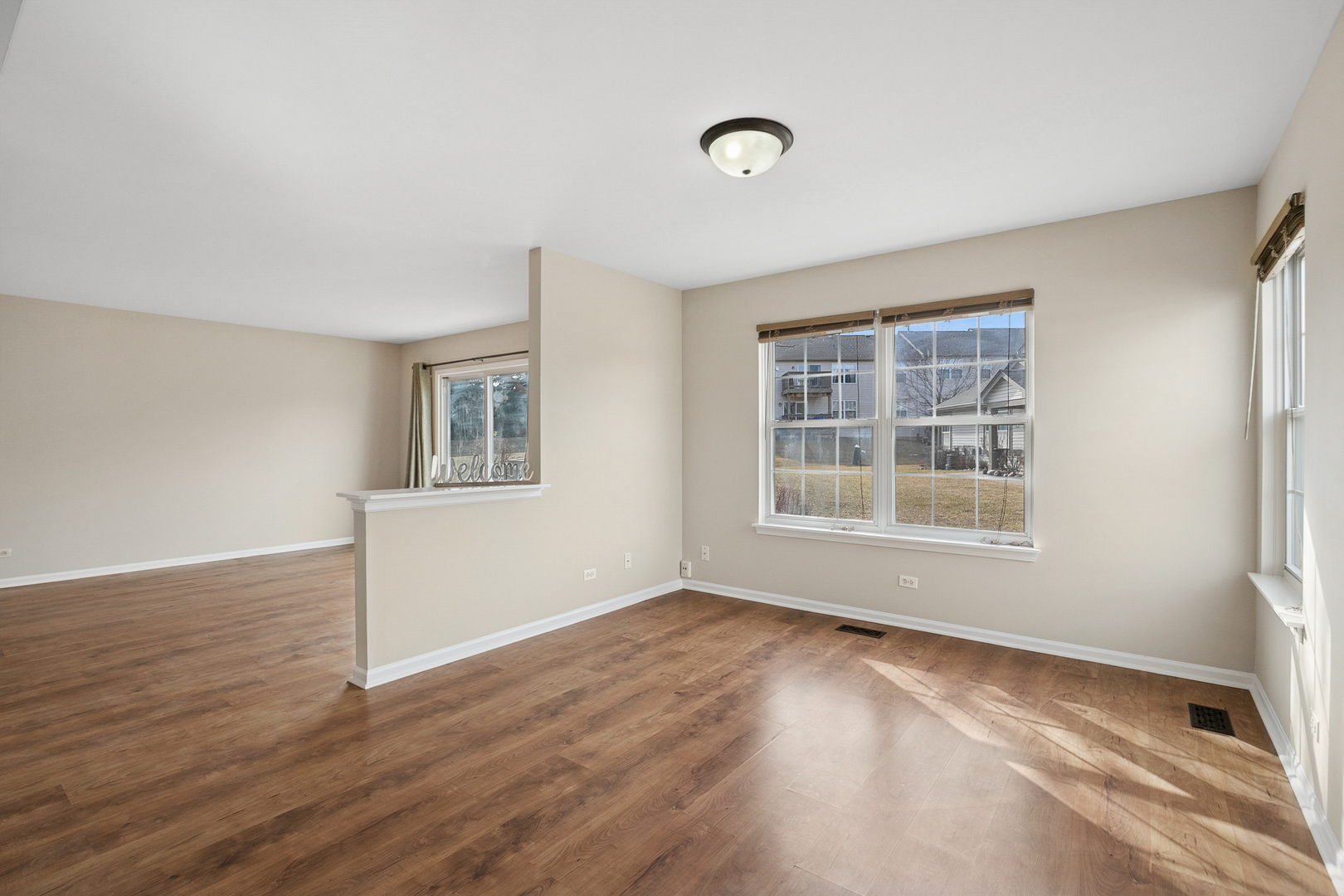 961 Sumac Court Lindenhurst, IL 60046 - Photo 8 of 22 a view of an empty room with wooden floor and a window