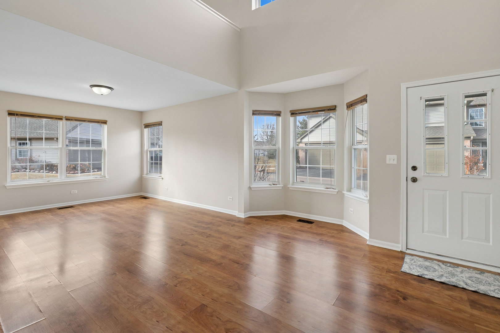 961 Sumac Court Lindenhurst, IL 60046 - Photo 10 of 22 a view of an empty room with wooden floor and a window