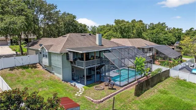 an aerial view of a house with swimming pool and big yard