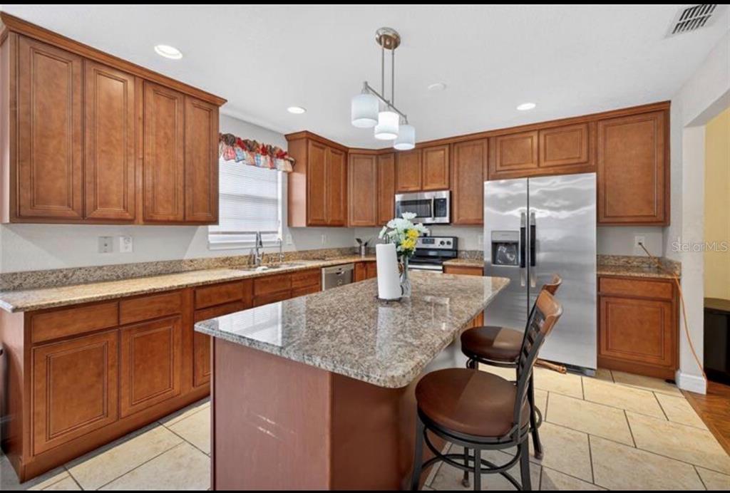 1922 Matthew Court Lakeland, FL 33813 - Photo 6 of 12 a kitchen with stainless steel appliances granite countertop a sink refrigerator and cabinets