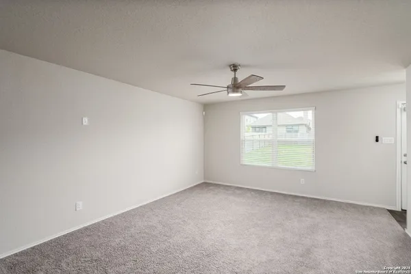 an empty room with windows and ceiling fan view