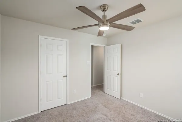 an empty room with a window and a fan