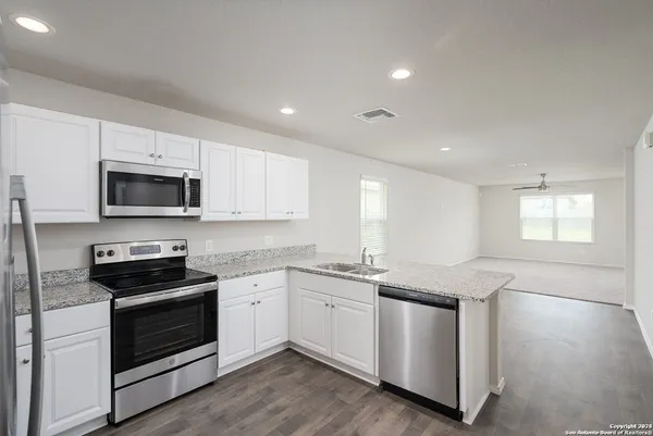 a kitchen with stainless steel appliances granite countertop a sink a stove a microwave and cabinets