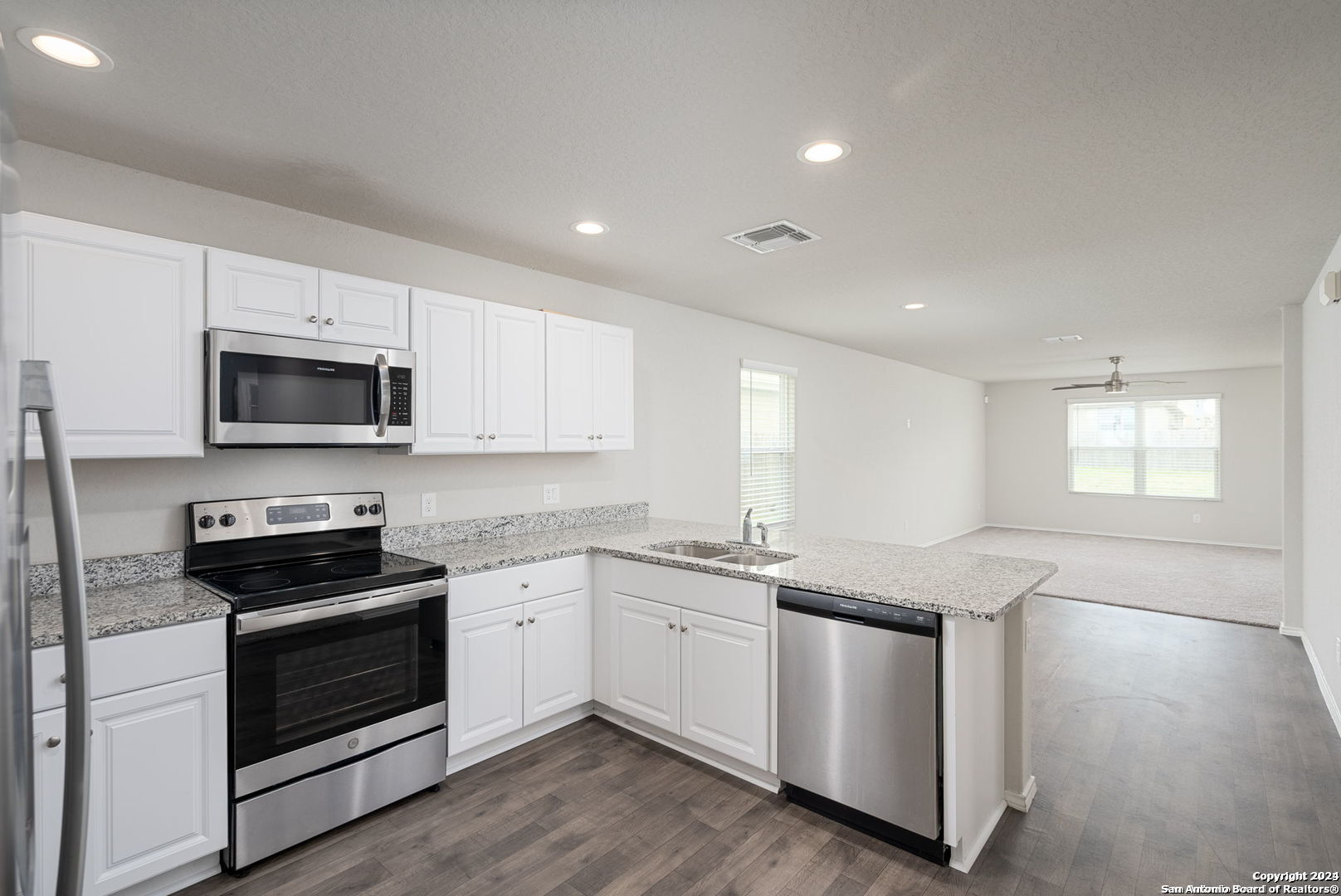 3619 Storm Moon Converse, TX 78109 - Photo 7 of 28 a kitchen with granite countertop white cabinets and white appliances