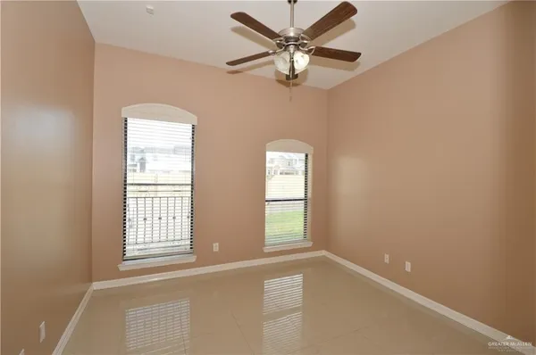 an empty room with windows and fan