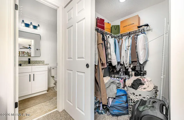 a view of walk in closet with clothes and shoes