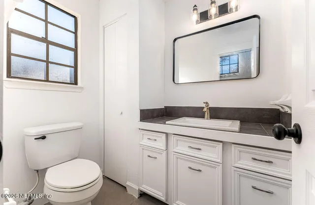 a bathroom with a toilet sink and mirror