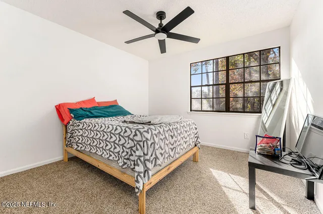 a bedroom with a bed dresser and a window
