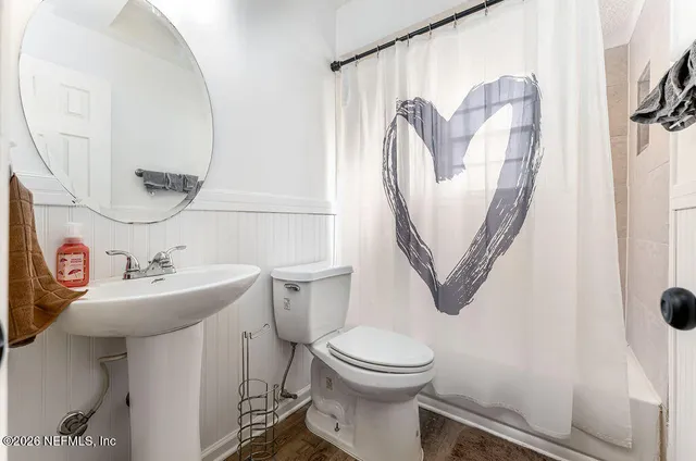 a bathroom with a toilet sink and mirror