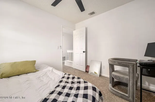 a bedroom with a bed and a chair with the view of a room