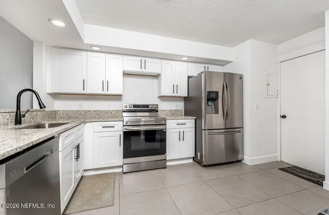 a kitchen with a refrigerator sink and cabinets
