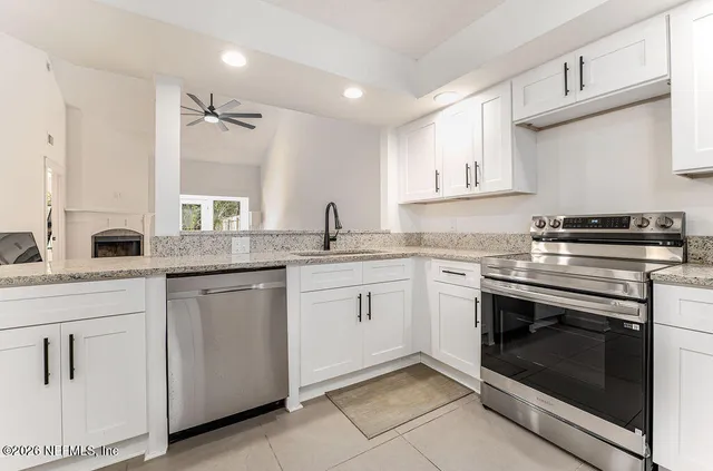 a kitchen with white cabinets appliances and sink