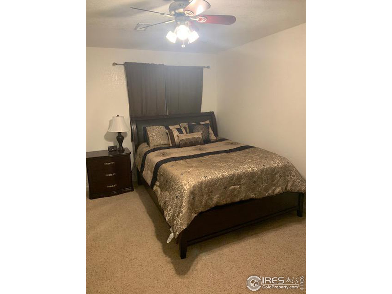 1821 Robin Road Sterling, CO 80751 - Photo 8 of 12 a bedroom with a bed and a chandelier