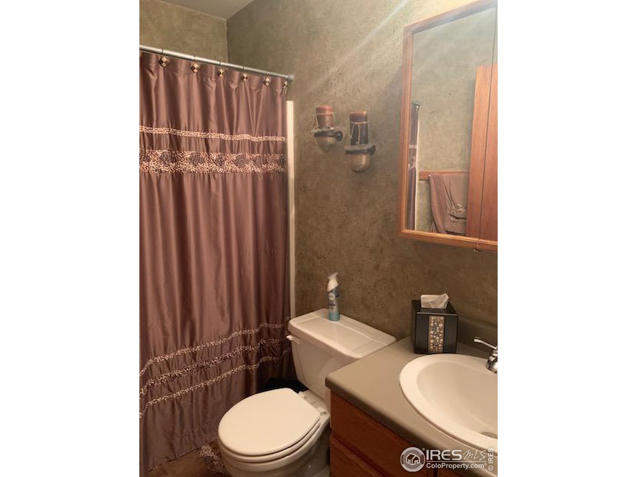1821 Robin Road Sterling, CO 80751 - Photo 9 of 12 a white toilet sitting next to a bathroom sink