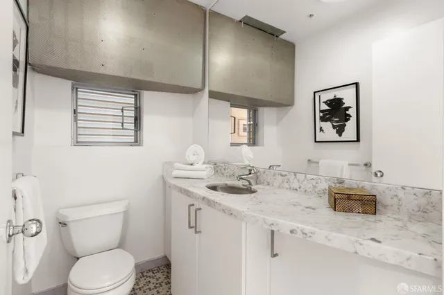 a bathroom with a toilet sink and mirror