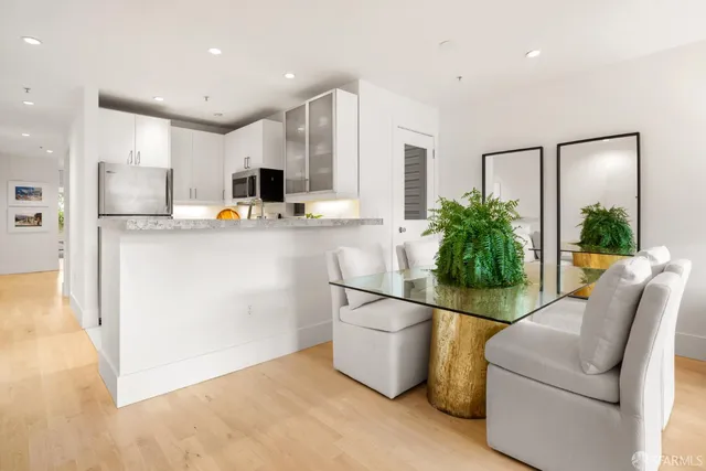 a kitchen with stainless steel appliances a refrigerator and a couch