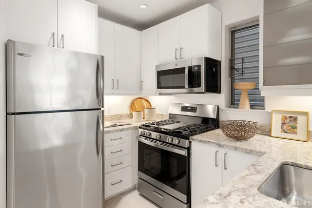 a kitchen with stainless steel appliances a refrigerator stove and microwave