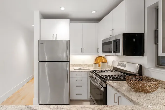 a kitchen with stainless steel appliances granite countertop a stove a refrigerator and a stove