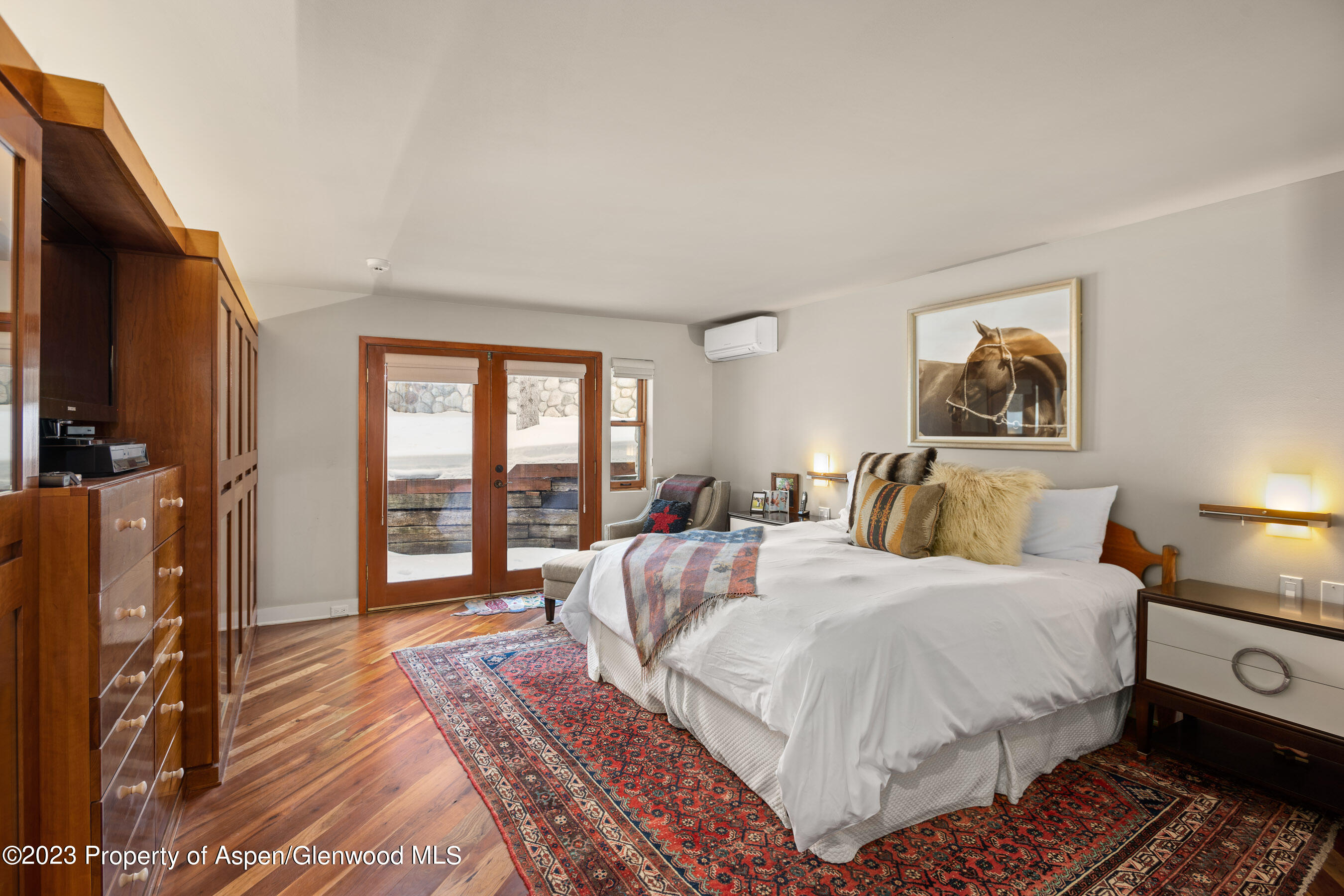 1402 Crystal Lake Road Aspen, CO 81611 - Photo 12 of 22 a bedroom with a large bed a flat tv screen and a dresser