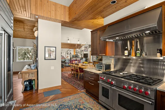 a kitchen with stainless steel appliances granite countertop a stove a refrigerator and a dining table view