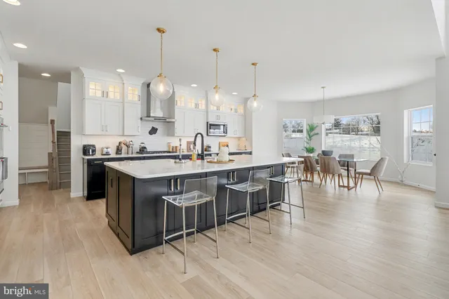 a kitchen with stainless steel appliances granite countertop a kitchen island a stove a table and chairs