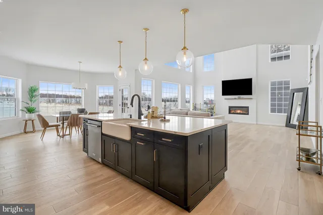 a kitchen with stainless steel appliances granite countertop a sink a stove and a wooden floor