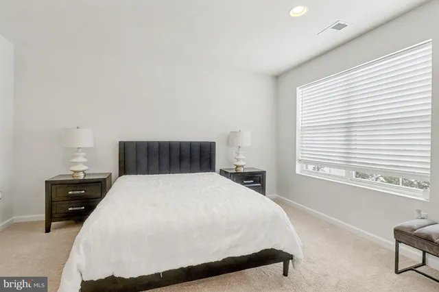 a large bed sitting in a bedroom next to a window