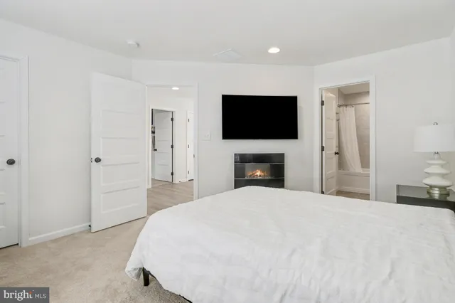 a large bedroom with a bed and a flat screen tv