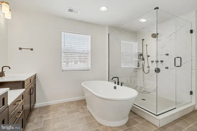 a bathroom with a tub sink and mirror