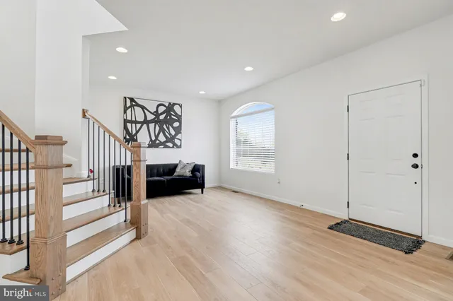 a view of a livingroom with entryway wooden floor and staircase