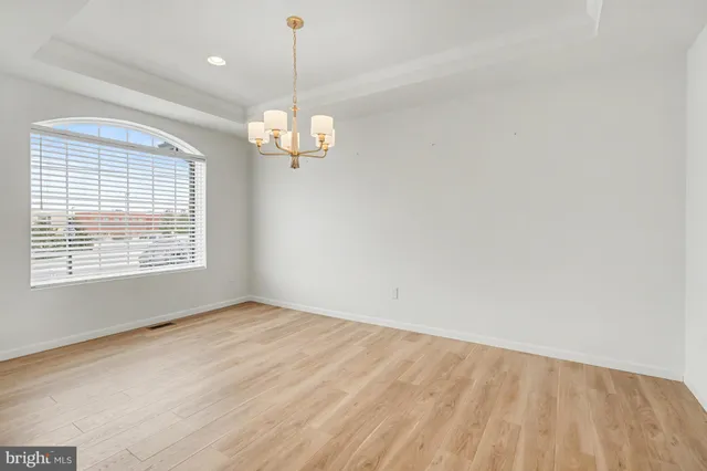 a view of empty room with wooden floor and ceiling fan