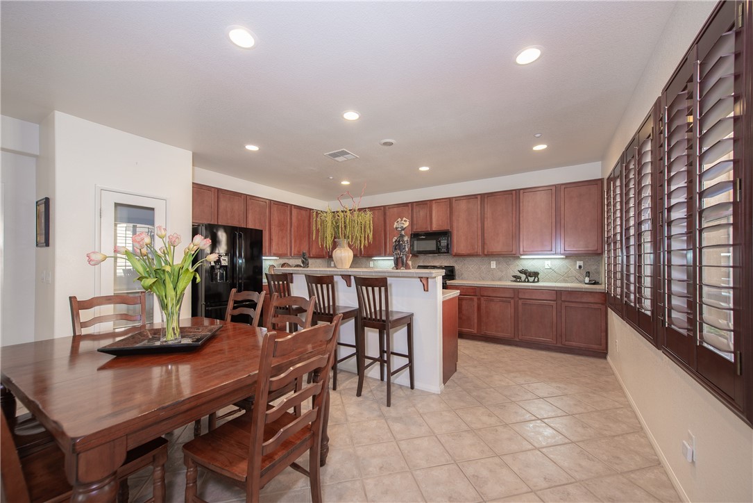 7353 Ellena W, Unit 52 Rancho Cucamonga, CA 91730 - Photo 7 of 30 The spacious kitchen and dining room are have plenty of recessed lighting and windows that overlook the courtyard. The entrance to the 2 car attached garage is to the left.