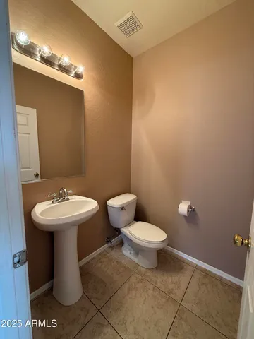 a bathroom with a sink a toilet and mirror