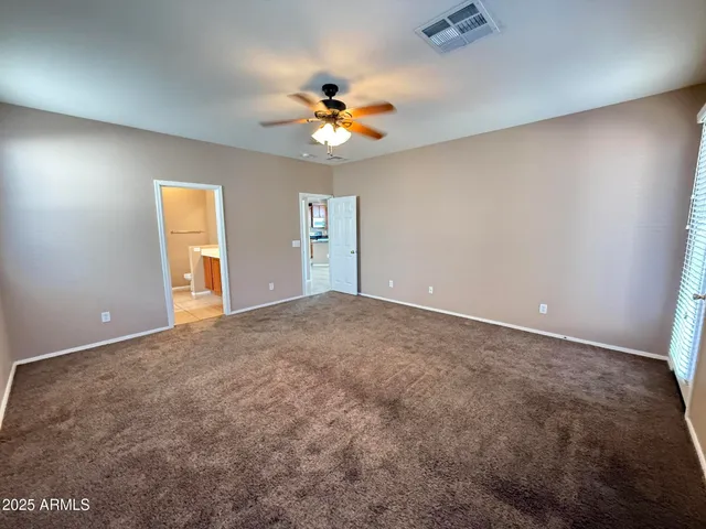 an empty room with closet and a chandelier fan