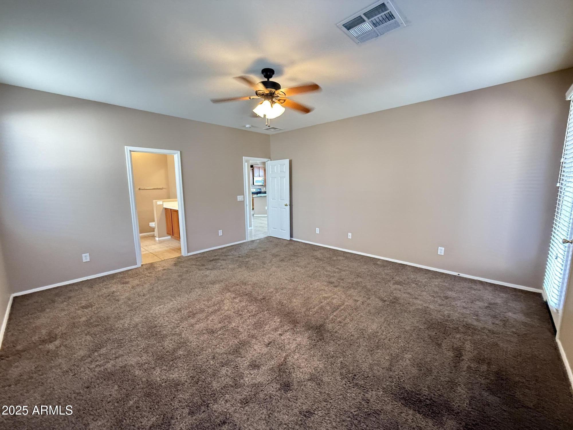 11752 West Foothill Drive Sun City, AZ 85373 - Photo 18 of 48 an empty room with closet and a chandelier fan