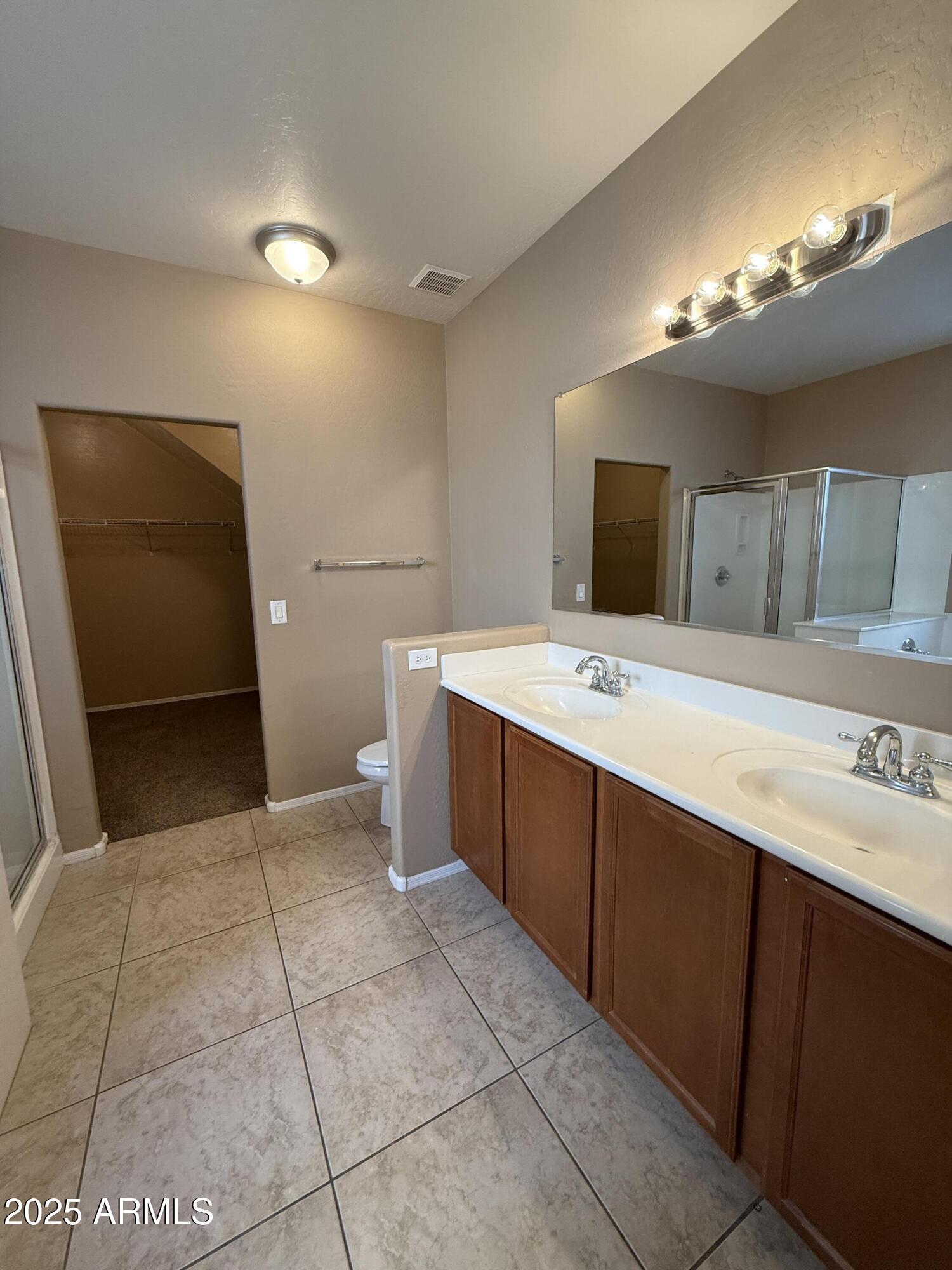 11752 West Foothill Drive Sun City, AZ 85373 - Photo 21 of 48 a bathroom with a sink a large mirror and a vanity